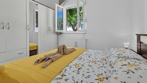 A bedroom with a bed, a window, a wardrobe, and a radiator.