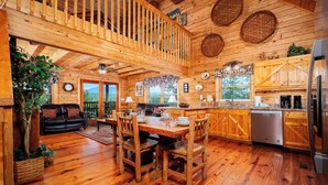 L’intérieur d’un chalet en bois comprend un coin repas, une cuisine et un balcon agrémenté de paniers en osier.