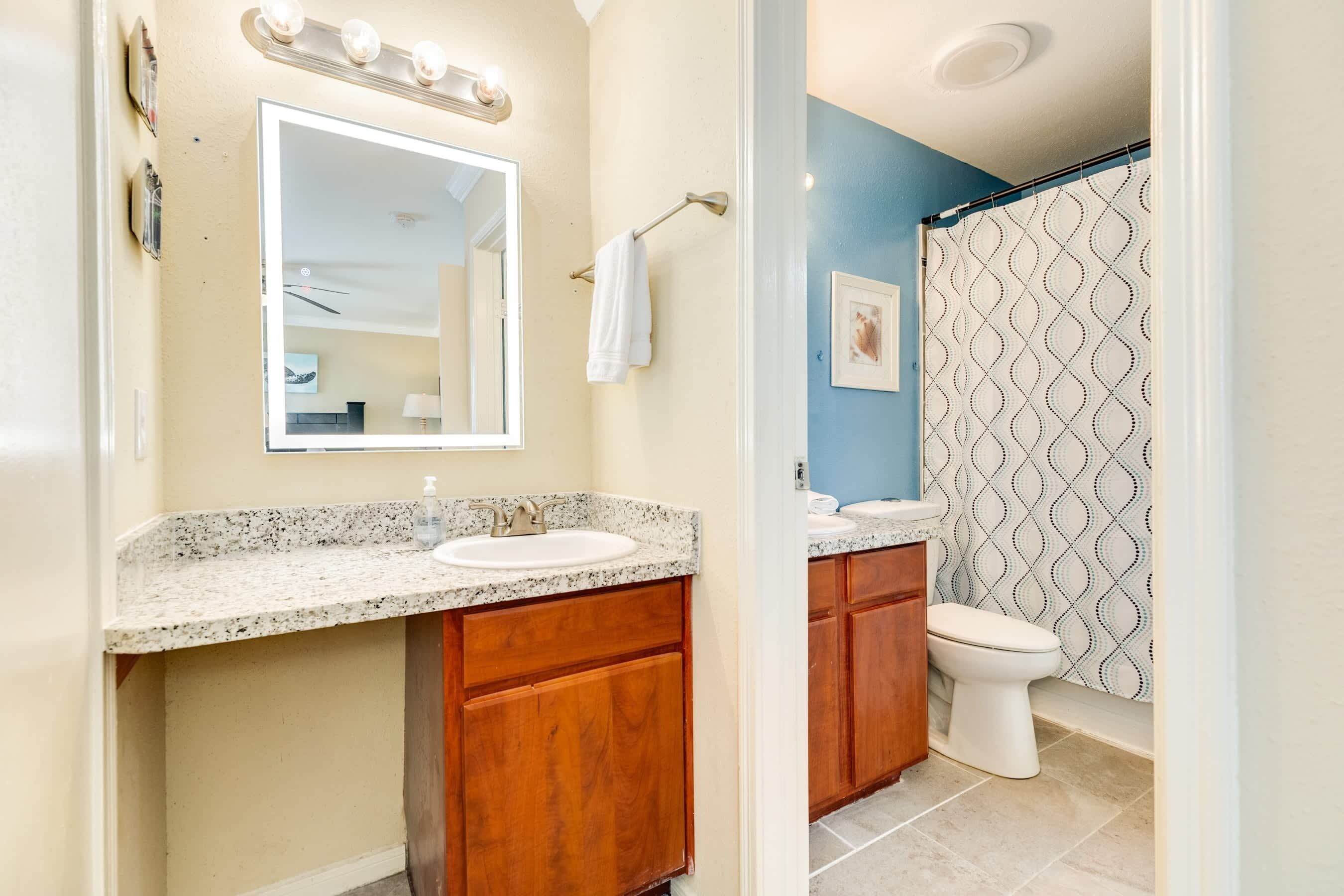 Une salle de bain avec un double lavabo, un meuble-lavabo et un rideau de douche.
