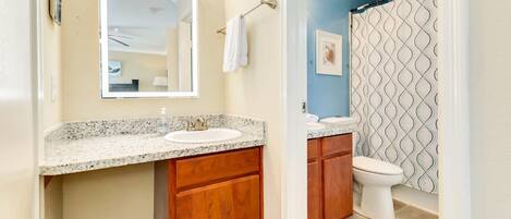 Une salle de bain avec un double lavabo, un meuble-lavabo et un rideau de douche.