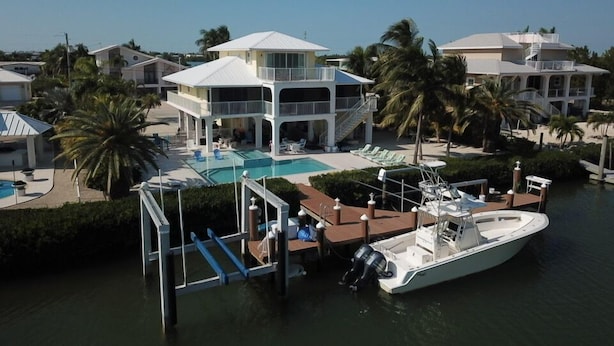 A resort with a large pool, a boat dock, and multiple buildings with balconies. - Outstanding pool and outdoor area 5 minute walk to beach! (Marathon)