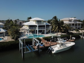 A resort with a large pool, a boat dock, and multiple buildings with balconies.
