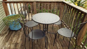A wooden deck with a round metal table and four chairs. - Comfortable 3BR Craftsman Bungalow in Milwaukee Bay View Neighborhood Sm Dog OK (Milwaukee)