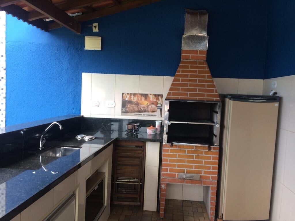 A kitchen with a brick oven, a sink, and a refrigerator.