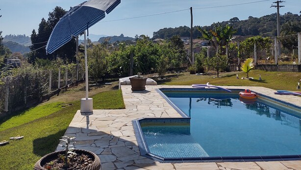 A swimming pool with a stone deck, a solar umbrella, and a potted plant. - Farm in Socorro wi-fi, solar heated pool, hot tub  (Socorro)