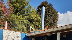 A patio area with a tiled backsplash, a wooden deck, and a brick chimney. - Farm in Socorro wi-fi, solar heated pool, hot tub  (Socorro)