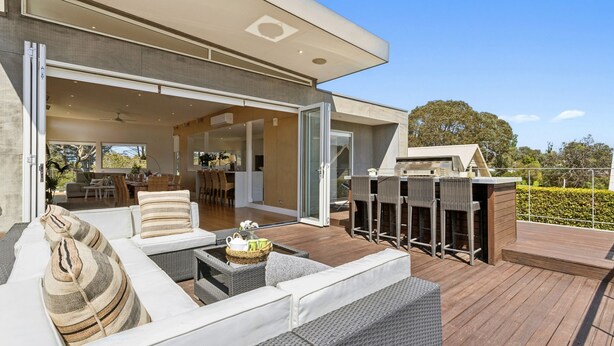 An outdoor deck with a sofa, chairs, and a grill area. - Fairway View (FLINDERS)