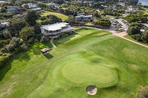 A golf course with a clubhouse, surrounded by residential properties.