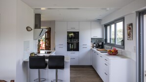 Una cocina moderna con gabinetes blancos, encimera negra y ventana que aporta luz natural.