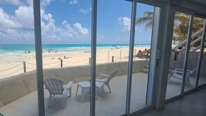 A beach view from a balcony with chairs and a table. - 2 Steps to the Beach 2 bedroom apartment (Zona Hotelera)