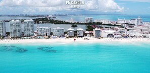 A coastal cityscape with high-rise buildings, a beach, and clear turquoise waters. - 2 Steps to the Beach 2 bedroom apartment (Zona Hotelera)