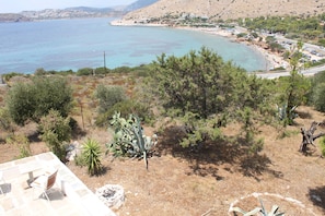 A coastal landscape with a beach, parked cars, and a road. - Aegean traditional home in Athens Riviera (Thimari)