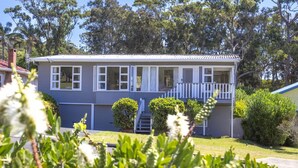 A two-story house with a front porch, a small staircase, and a well-maintained lawn. - Surf & Turf Retreat in Mollymook (Mollymook)