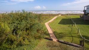 Un camí marítim que condueix a una construcció de fusta amb vista a l'oceà.