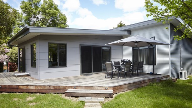 A modern house with a deck, a patio with outdoor furniture, and a covered area with an umbrella. - Cuballa - Just a few minutes flat  walk to town & the river .Modern clean house (Bright)