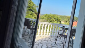 A balcony with a stone floor, white balustrade, and outdoor furniture. - LAZAROS villa in Agios Matheos Corfu  (AGIOS MATHEOS CORFU)