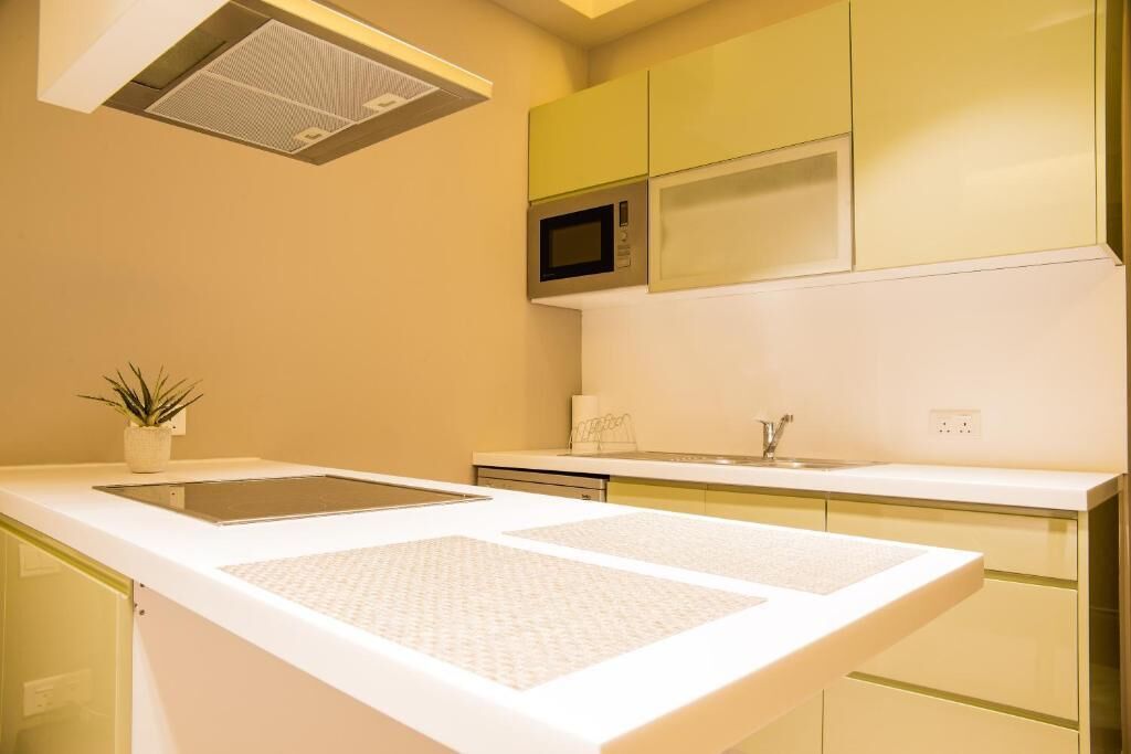 A modern kitchen with a microwave, a sink, and a countertop with a plant.