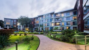 A modern multi-story hotel with a landscaped garden and a curved pathway. - Accra Fine Suites  (Accra)