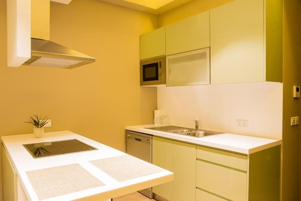 A compact kitchen with a microwave, stove, and dishwasher.