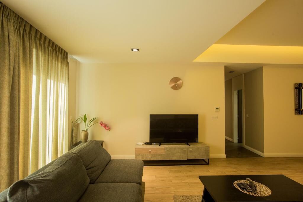 Una sala de estar moderna con un sofá, un televisor de pantalla plana y una mesa de centro.
