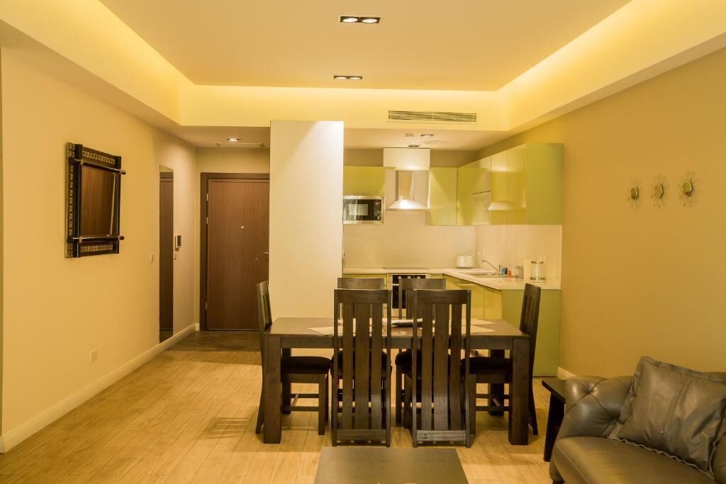 Een compacte leefruimte met een eethoek, kitchenette en een bank.