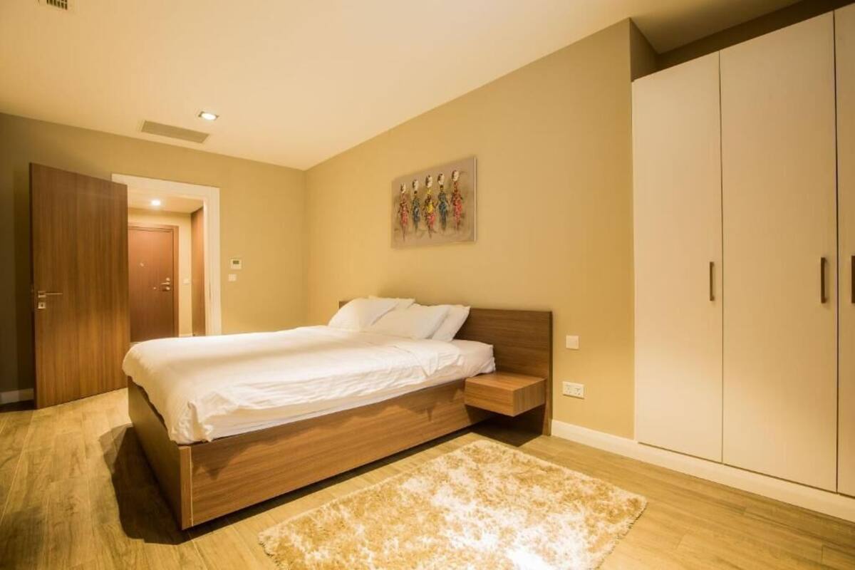 Ein Schlafzimmer mit einem hölzernen Bett, einem beigen Teppich und einem Kleiderschrank.