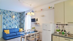 A compact living space with a sofa, dining table, and kitchenette. - Charming apartment, mit pools, in a residence  just a few minutes from the lake (LAZISE)
