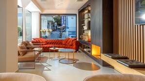 Una sala moderna con sofá, mesa de centro y vista a la calle.