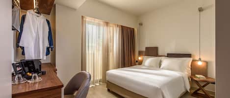 Habitación de hotel con cama, escritorio, silla y espejo.