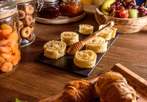 Een houten tafel met potten volnoten, een fruitschaal en gebak.