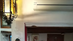 A kitchen with a hanging cloth, a wooden door, and shelves with kitchen items. - THE GECKO ON THE ROOFS OF GENOA<br>010025-LT-1029 (Genova)