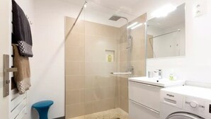 Un bagno con doccia, WC e una lavatrice Whirlpool.