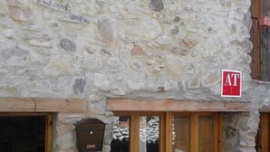 Un edificio de piedra con un buzón y una puerta.