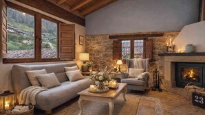 A cozy living room with a fireplace, a sofa, a chair, and a coffee table. - Rural apartment L'Arboleu de Traspeña for 2 people (Proaza)