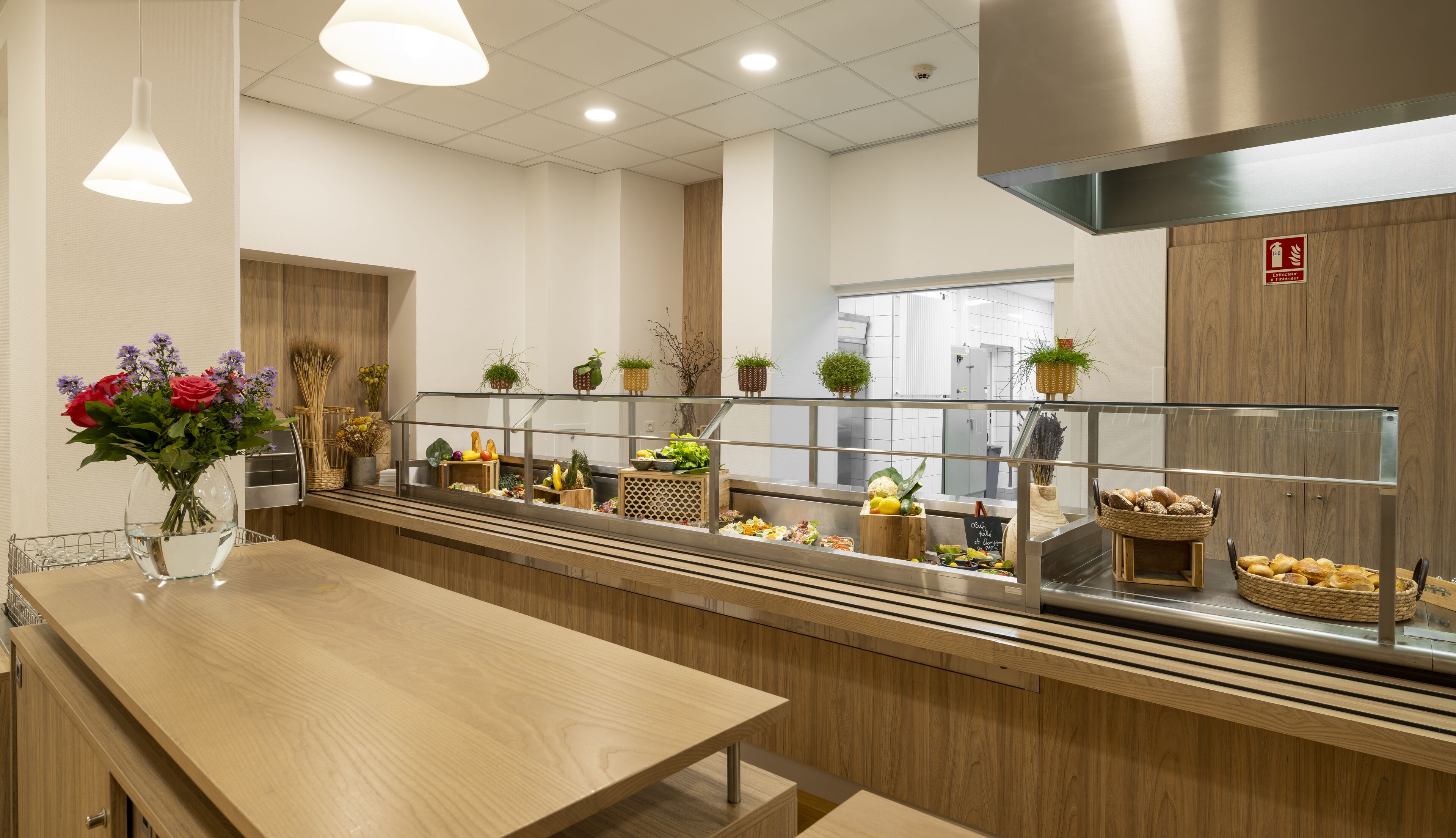 Una cocina moderna con una encimera larga, electrodomésticos de acero inoxidable y armarios de madera.
