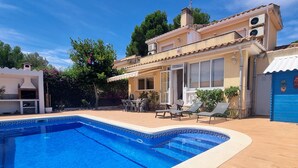 A two-story house with a swimming pool, outdoor furniture, and a covered patio area. - Nice house for 8 people with private pool, wifi and 400m from the sea. (Ametlla de mar)