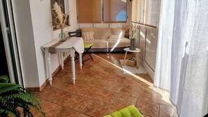 A cozy living room with a sofa, a dining table, and a small side table. - Nice house for 8 people with private pool, wifi and 400m from the sea. (Ametlla de mar)