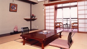 A traditional Japanese room with tatami flooring, a low wooden table, and shoji screens. - Hotel Shiiya (Sado)