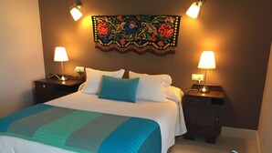 A neatly made bed with a blue and white striped bedspread, two bedside lamps, and a decorative wall hanging above. - Rural apartment El Hospital de Villahormes for 4 people (Llanes)