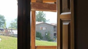 Ein Holztürrahmen mit Blick auf ein Haus und eine Rasenfläche.