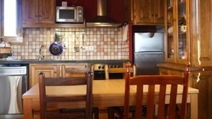 Eine Küche mit Holzausstattung, einer Mikrowelle, einem Herd und einem Kühlschrank.
