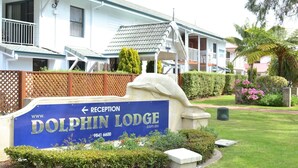 A reception sign for Dolphin Lodge with a website URL and phone number. - SELF CONTAINED-2 Bdrm Apartments (Albany)
