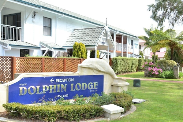A reception sign for Dolphin Lodge with a website URL and phone number.