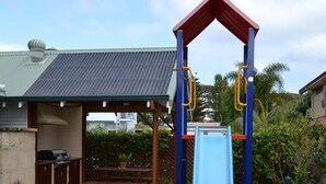 A backyard with a slide, barbecue area, and a covered seating space. - SELF CONTAINED-2 Bdrm Apartments (Albany)