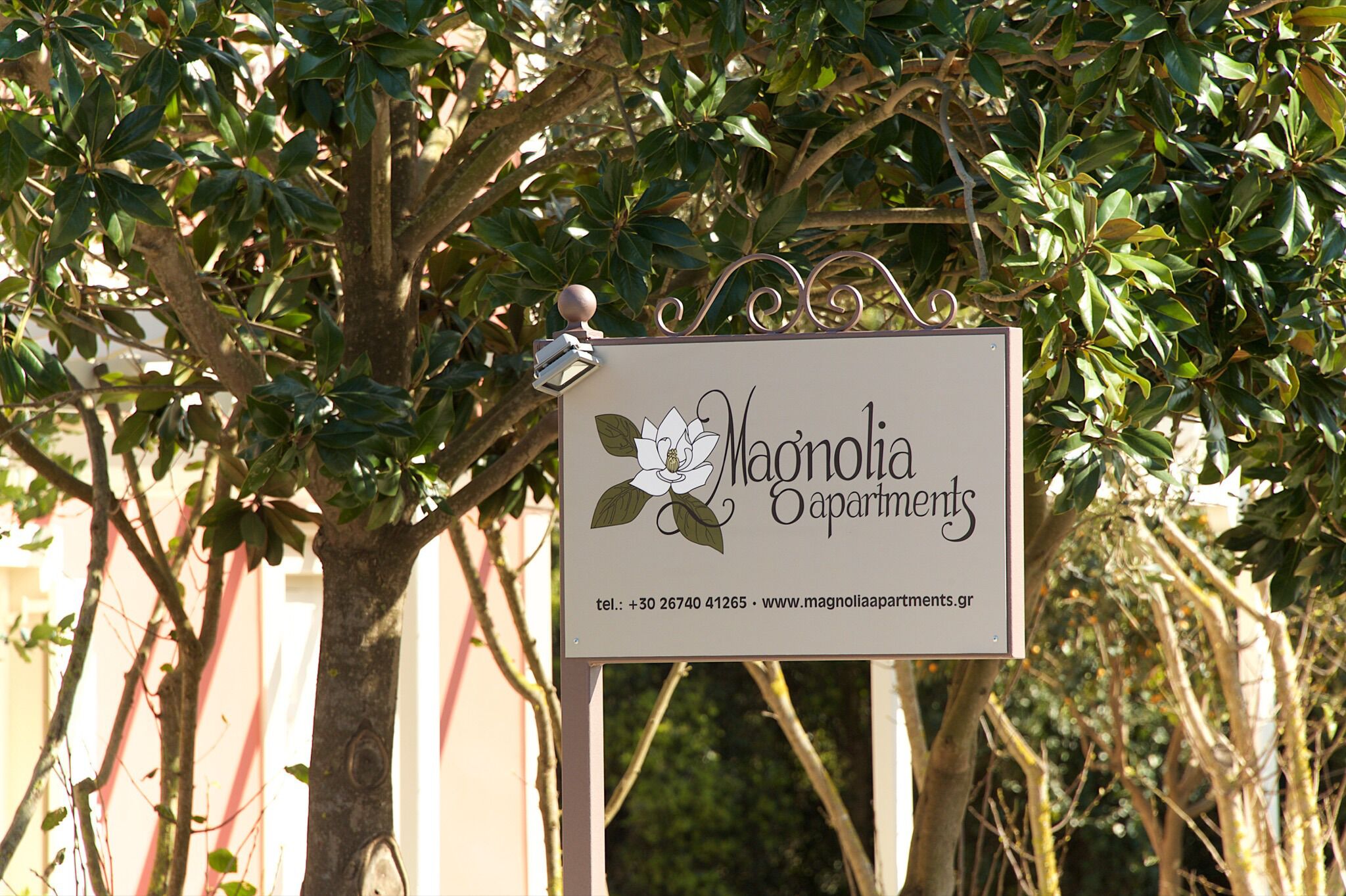 Placa de identificação dos Apartamentos Magnolia, com informações de contato.