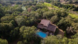 An aerial view of a house with a swimming pool surrounded by dense greenery and a hilly landscape. - House A Sùvara ***** private pool, park with trees 15 hectares, 5 min PORTICCIO (Cauro)