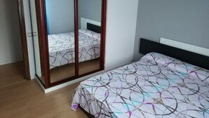 A bedroom with a bed, a wardrobe, and a mirror. - Apartment for groups in Logroño (Logroño)