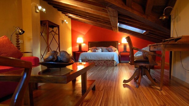 Une pièce confortable avec un lit, des meubles en bois et un plancher en bois.