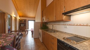 Una cucina con mobili in legno, forno a incasso e lavello.