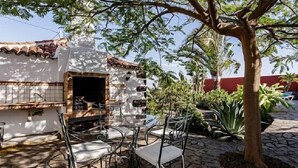 Une terrasse avec des sièges extérieurs et un mur en pierre.